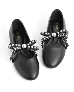 Close-up of black round-toe flats with silver studded bow and metallic buckle