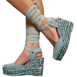 Elegant sage green lace-up wedge sandals featuring luxury rhinestone embellishments on heel
