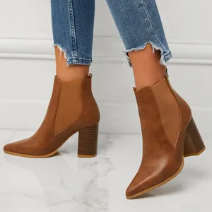 Detailed view of fashionable brown pointed-toe chunky heel boots with elastic side panels