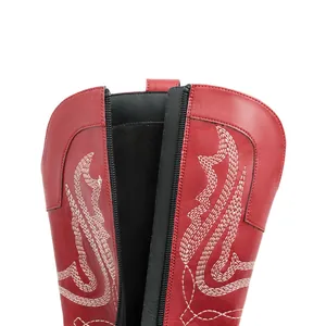 Vue détaillée en gros plan de bottes de cowboy en cuir rouge avec broderies blanches