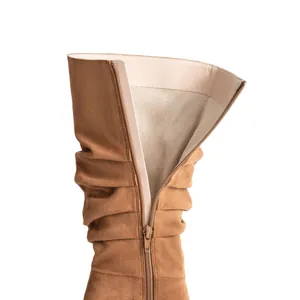 Dettaglio ravvicinato di stivali slouchy in pelle scamosciata marrone con cerniera e fodera