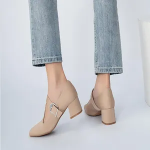 Close-up view of retro beige Mary Jane shoes with T-strap buckle and chunky heel on feet
