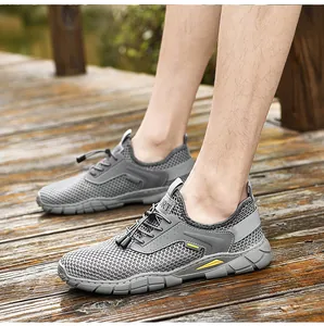 Dettaglio di scarpe estive da uomo in mesh grigio traspirante su un ponte in legno.