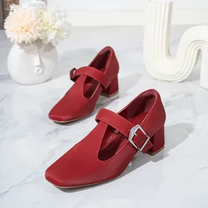 Close-up detail of red Mary Jane shoes with chunky heel and silver T-strap buckle
