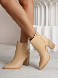 Side view of beige pointed toe ankle boots with chunky block heels and elastic panels