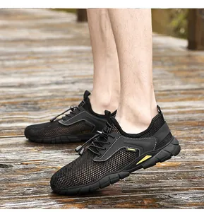 Vista laterale di scarpe da uomo in rete nera traspirante indossate su ponte di legno