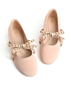 Detailed top-down view of nude ballet flats featuring elegant gold rivet cross-straps