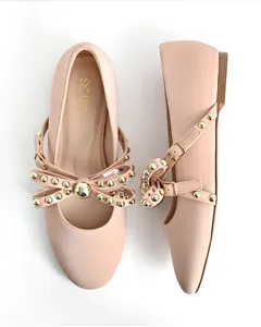 Elegant pink round-toe ballet flats featuring gold studs and a decorative buckle bow detail.