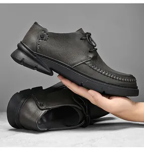 Gedetailleerd overzicht van handgemaakte stiksels op grijze heren casual leren werkschoenen