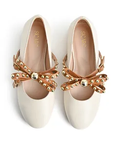 Detailed top view of beige round-toe flats featuring gold-studded brown bow straps.