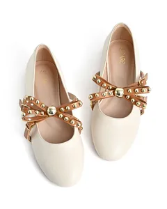 Detailed top-down view of off-white round toe flats with gold-studded bow straps.