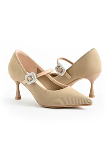 Detailed view of nude pointed-toe Mary Jane heels with sparkly rhinestone buckles.