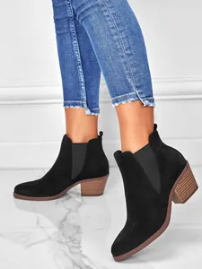 Detail view of black suede pointed toe ankle boots with chunky stacked heel