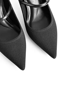 Close-up macro view of elegant black pointed-toe Mary Jane pumps featuring a knit texture.