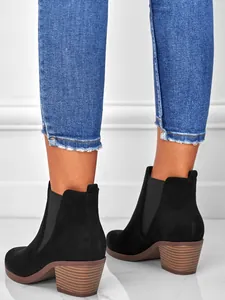 Detailed close-up view of elegant black suede pointed toe chunky heel ankle boots for women