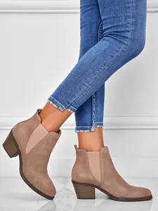 Close-up of taupe suede ankle boots with chunky heel and elastic side panel
