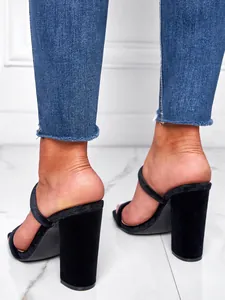 Detailed back view of sexy black velvet block heel sandals paired with blue denim jeans