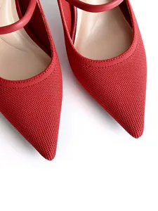 Close-up detail of red knit pointed-toe Mary Jane pumps featuring elegant straps