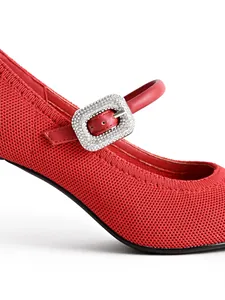 Close-up of red knitted Mary Jane high heel with sparkling rhinestone buckle detail.