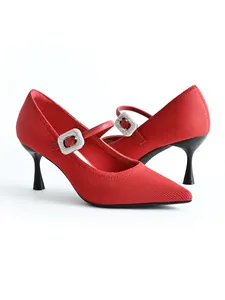 Close-up of red pointed-toe Mary Jane heels with sparkling rhinestone buckle and knit fabric.