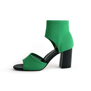 Detailed side view of green flyknit peep toe sandal with sturdy black block heel
