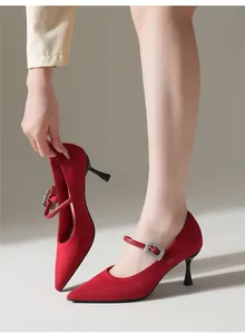 Close-up detail of red pointed-toe knit Mary Jane heels featuring a sparkling rhinestone buckle
