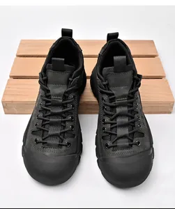 Bovenaanzicht van zwarte outdoor wandel- en werkschoenen op een rustieke houten palletplank