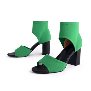 Close-up detail of breathable green fly-woven peep-toe sandals with black chunky heels