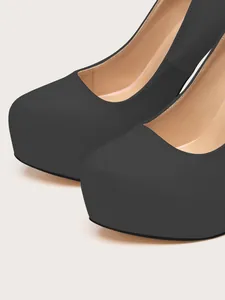 Detail showing the elegant black suede texture and round toe platform of these high heels.