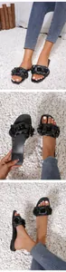 Close-up detail of black flat outdoor beach slides with elegant 3D flower decorations