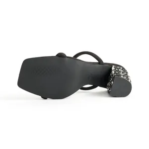 Bottom view of black square toe sandal featuring a black and white tweed chunky heel detail