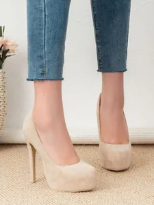 Detailed side view of elegant beige suede platform stiletto high-heel pumps worn by model
