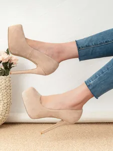 Detailed side view of elegant beige suede platform pumps featuring slim high stiletto heels