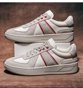 Dettaglio di sneaker da ginnastica tedesche in camoscio grigio e bianco con accenti rossi.