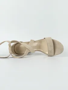 Top view of beige suede chunky heel sandals with cross-strap design and open toe.