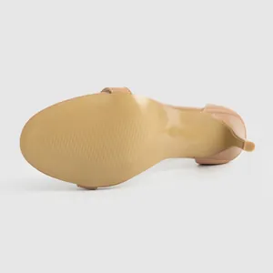 Vista ravvicinata della suola beige liscia e dell'elegante tacco a spillo del sandalo.