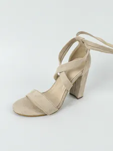 Detailed view of nude suede block heel sandals with elegant lace-up cross straps