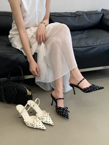 Detailed view of French-style polka dot pointed toe mules with elegant bow and slim heel