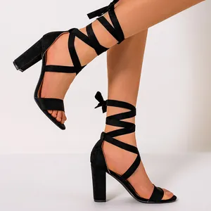Detailed side view of elegant black lace-up sandals featuring a chunky high block heel
