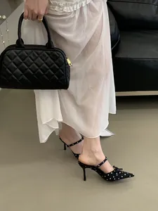 Close-up detail of French style polka dot stiletto mules with bow decoration and ankle strap