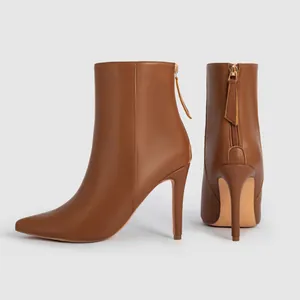 Detail view of brown pointed-toe ankle boots featuring a sleek back zipper design