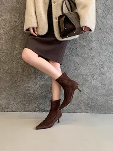 Elegantes botines de ante marrón oscuro con punta fina para mujer combinados con abrigo de invierno