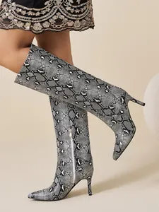 Detailed view of snake print pointed toe stiletto knee high boots with side zipper
