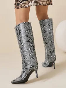 Macro detail view of fashionable snake skin pattern on stiletto pointed toe knee-high boots