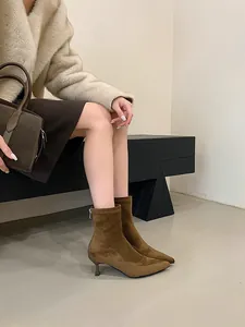 Detalle de botines de gamuza marrón con punta fina y tacón de aguja para mujer de moda