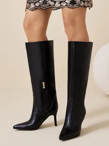 Close-up of black stiletto knee-high boots featuring pointed toe and side zipper details