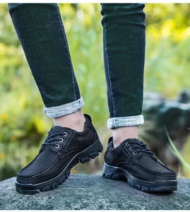 Detail van ademende zwarte leren outdoor vrijetijdsschoenen voor heren op een rots