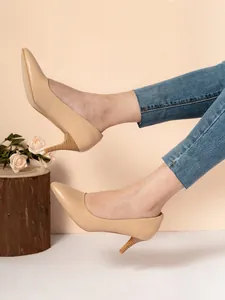 Detailed side view of apricot pointed-toe kitten heel pumps worn with denim jeans