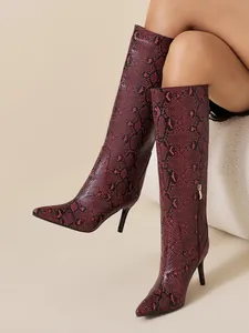 Chic red snakeskin knee high stiletto boots featuring a pointed toe and side zipper detail