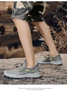 Gedetailleerd overzicht van grijze ademende mesh sportschoenen op rotsachtig terrein